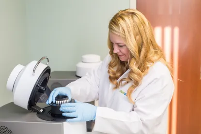 Female student in a lab coat working with laboratory equipment