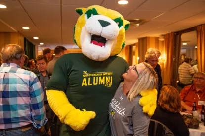 Alumni posing with Wildcat Willy