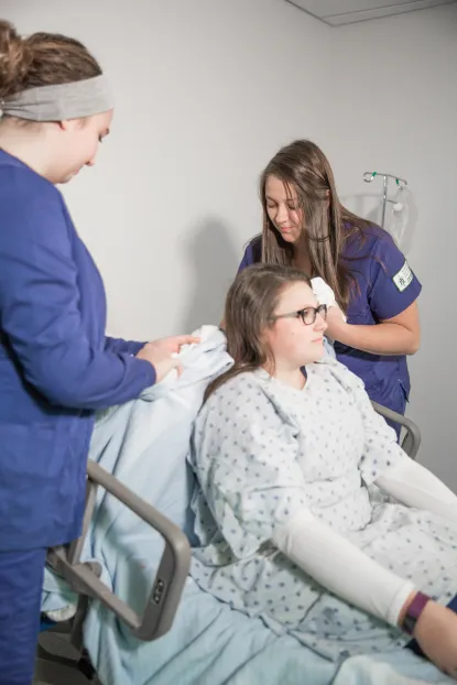 Students working with a patient