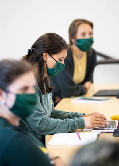 Three students in classroom wearing masks