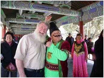 Dr. Ira Hutchison poses with a traditional figure at a park in Beijing.