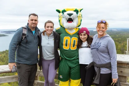 Family posing with Wildcat Willy on top of Sugarloaf