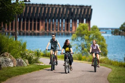 Three student riding a bike along the lake