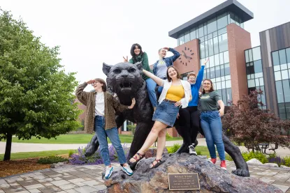 Students gathered on the NMU Wildcat statue outside Jamrich Hall.