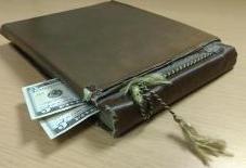 Tattered book with money sticking out of it