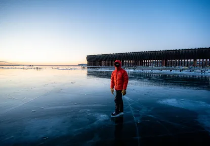 Student skating on lake superior in front of the ore dock
