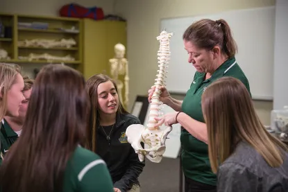 Professor showing spine in athletic training lab