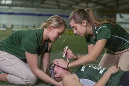 Students giving a lacrosse athlete a concussion test