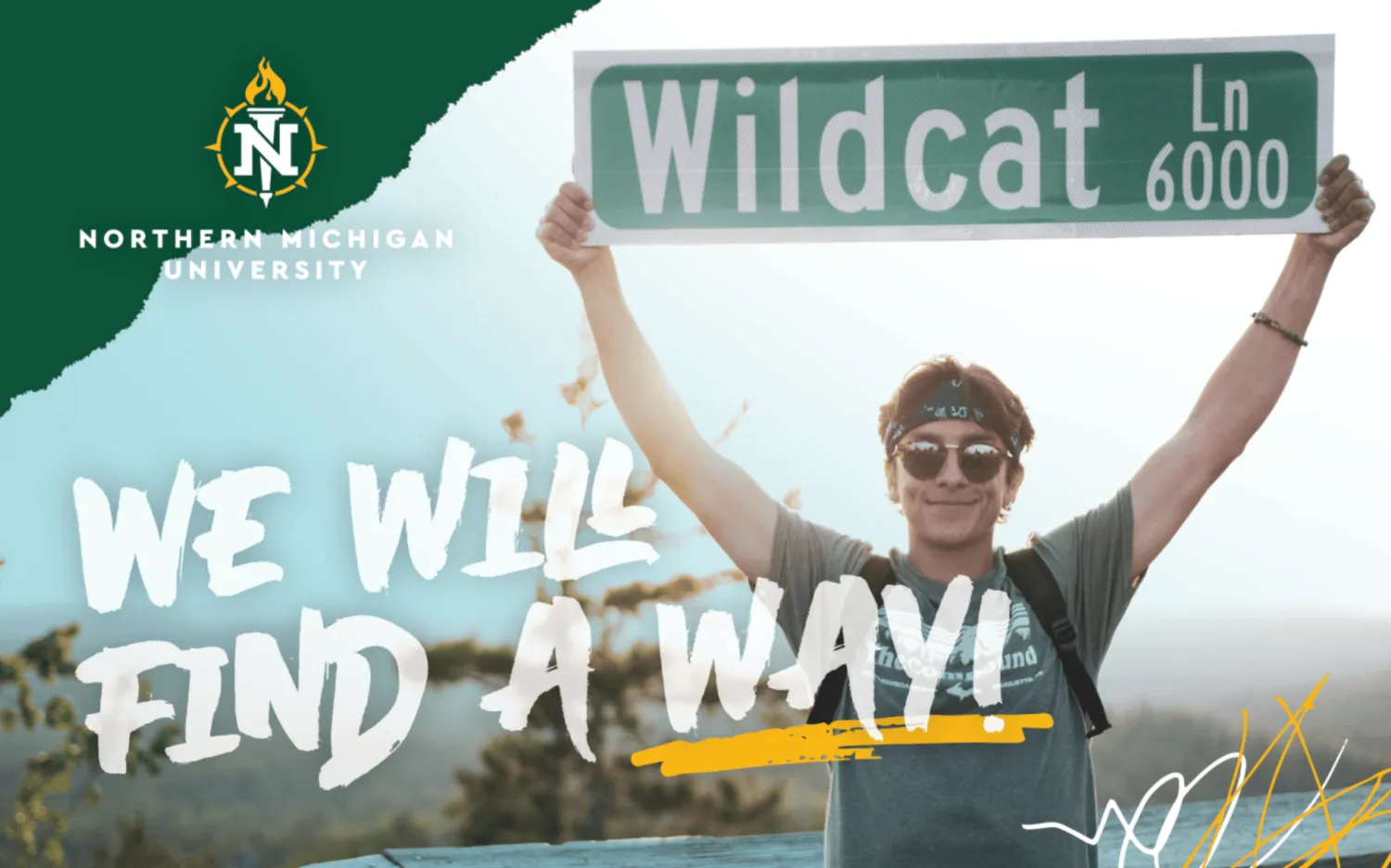 Recruitment postcard male student holding Wildcat Lane street sign above his head on top of a mountain