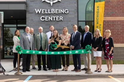President Tessman standing outside the WellBeing center with a group of people during the ribbon cutting ceremony