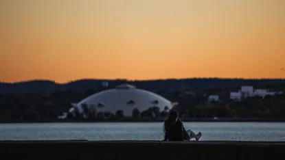 Student sitting on the breakwater overlooking the NMU Superior dome.