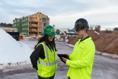a female and male construction student talking at a job site